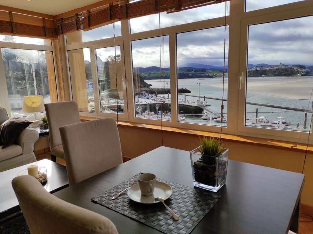 Mesa del salón y ventanas con vistas al muelle