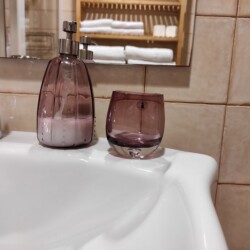 Lavamanos con un vaso y un dispensador de jabón