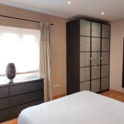 Habitación con dos muebles y cama doble
