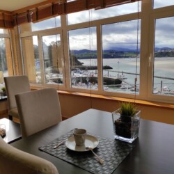 Mesa del salón y ventanas con vistas al muelle